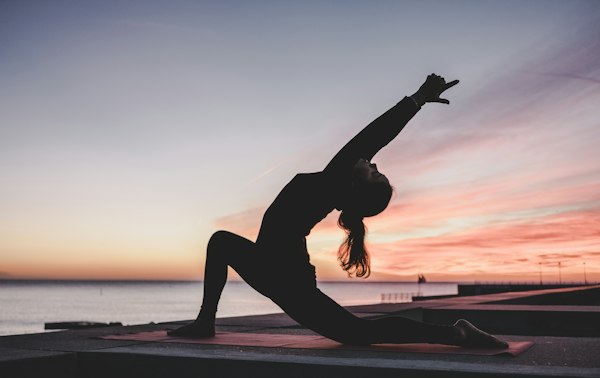 Person practicing yoga for wellness